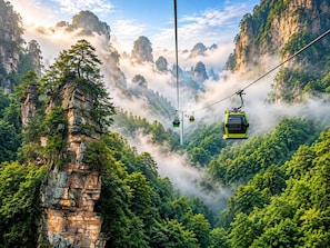 A cable car system in a mountainous area with lush greenery and rocky cliffs. - Xiyoon Yangjiajie Mountain Inn (Zhangjiajie)
