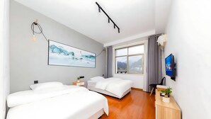 Quarto de hotel moderno com duas camas, uma janela grande, televisão de tela plana e um quadro na parede.