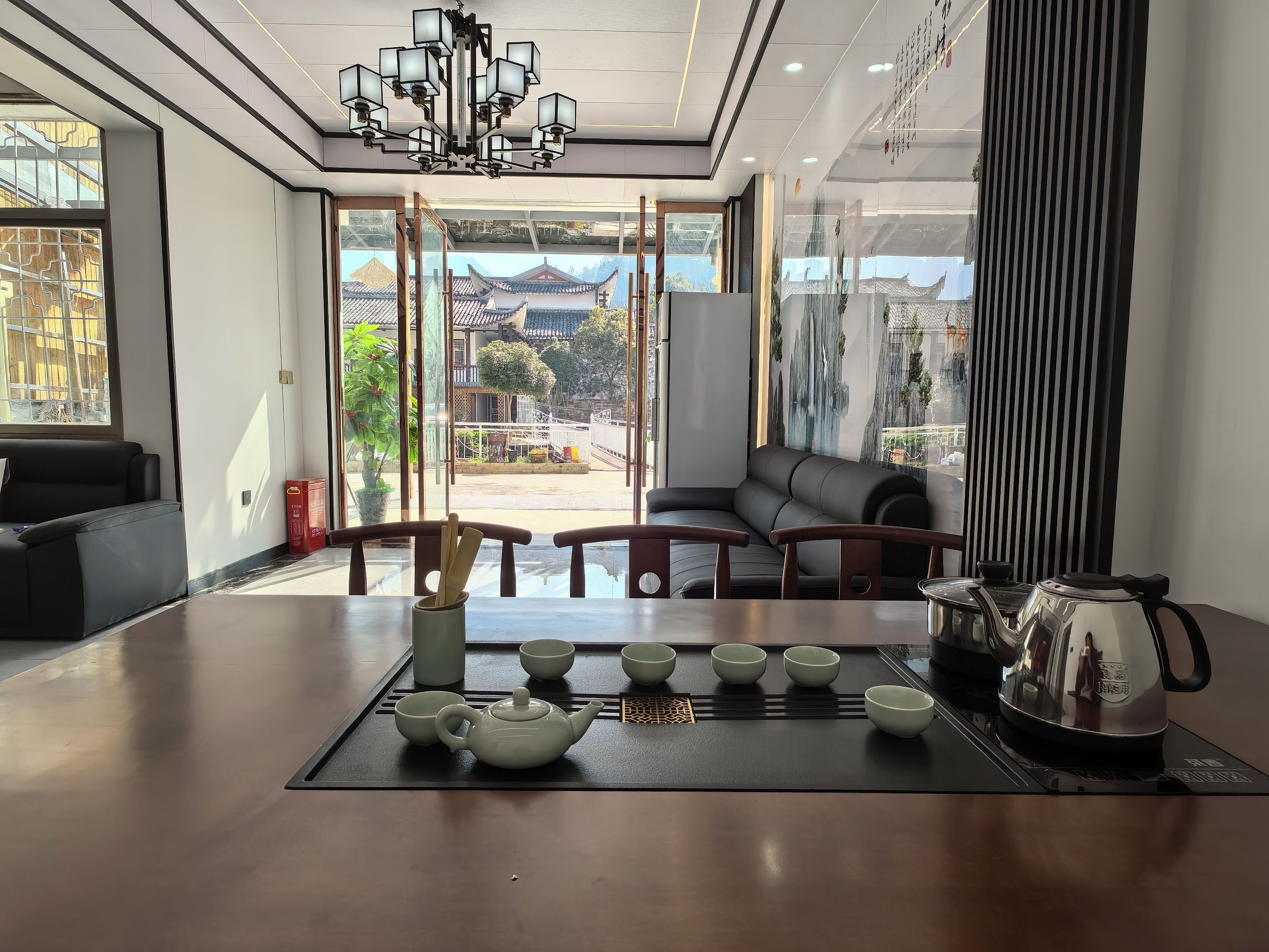 Un interior moderno con una zona de comedor que incluye una tetera, tazas y una hervidora sobre un tapete.