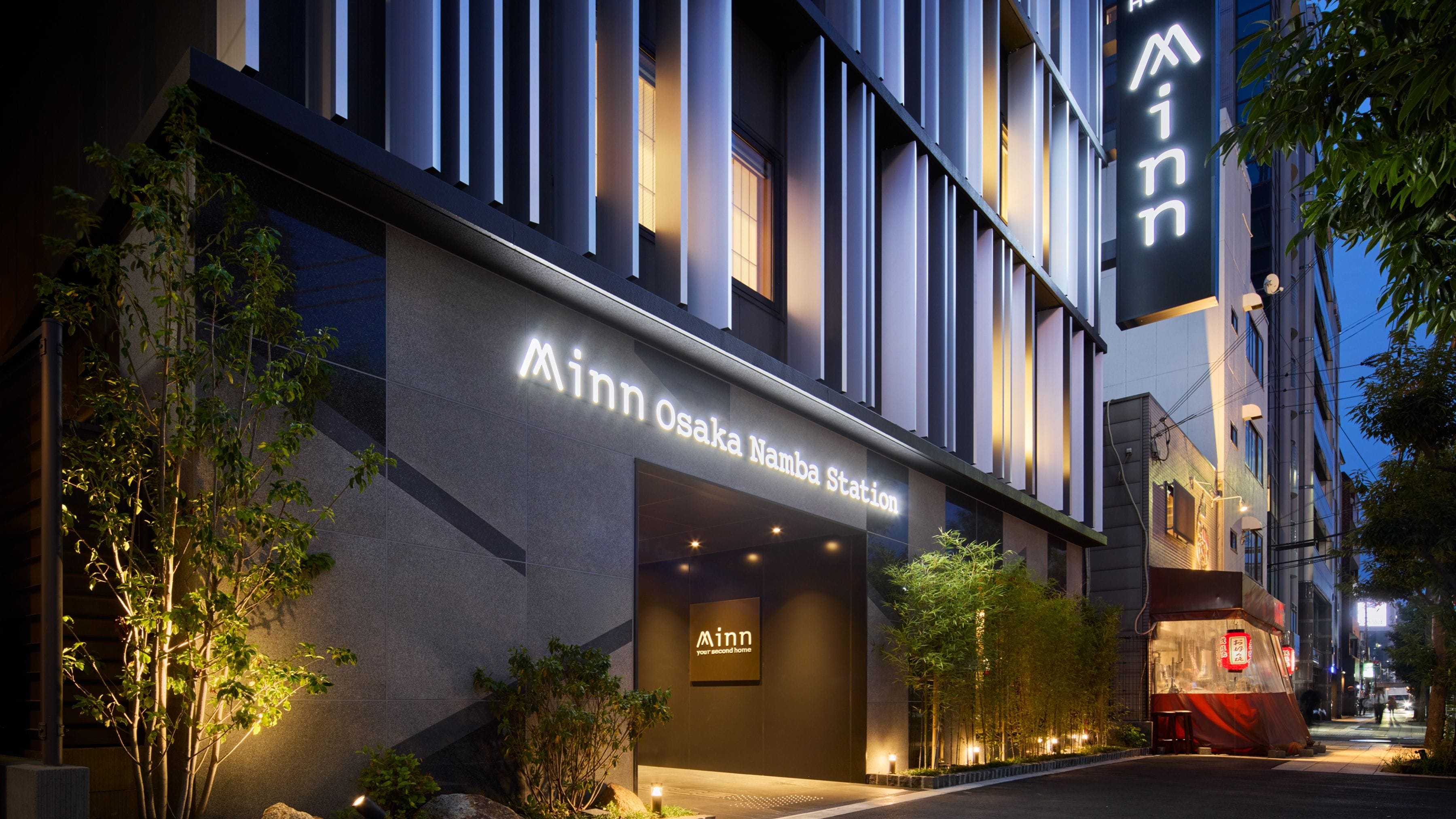 A modern building with a sign reading 'Minn Osaka Namba Station.'