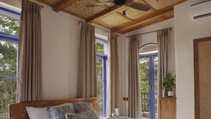 A bedroom with a large bed, wooden headboard, and a ceiling fan. - Staymaster Cove Villa (Parra)