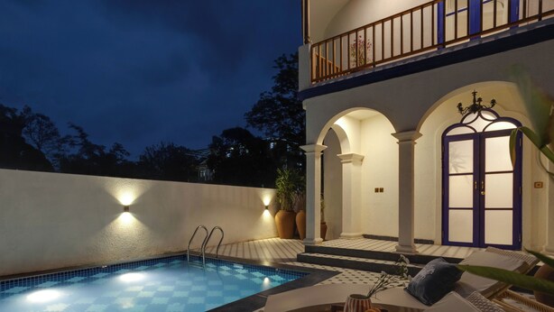 A swimming pool with a sunken seating area, a door with glass panels, and a balcony with a railing. - Staymaster Cove Villa (Parra)