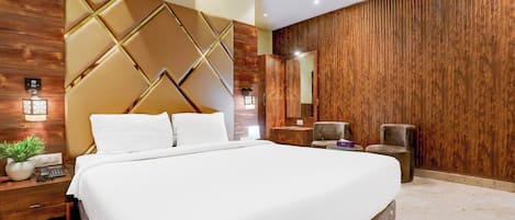 Een moderne slaapkamer met een groot bed, houten lambrisering, een inbouwkleerkast en een nachtkastje met een lamp.