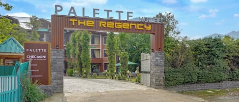 Entrada de um hotel com uma placa que diz 'PALETTE THE REGENCY'.