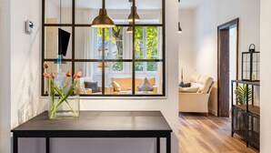 Et moderne interiør med et stort vindue, et sort bord med en blomstervase og en sofa.