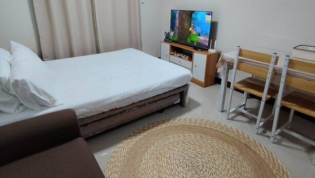 Ein Hotelzimmer mit Bett, Fernseher, Schreibtisch und Stuhl.