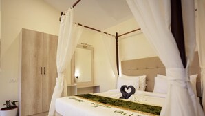 A bedroom with a canopy bed, a wooden wardrobe, a bedside table, and a potted plant. - The Divine Valley By Devandhari (Sakleshpur)