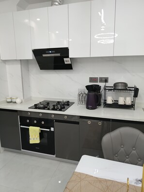 A modern kitchen with a gas stove, oven, and coffee maker. - Modern cozy Retreat (Nairobi)