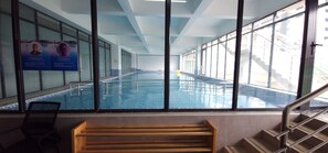 A swimming pool with clear glass walls, a wooden bench, and a staircase leading to an upper level. - Modern cozy Retreat (Nairobi)