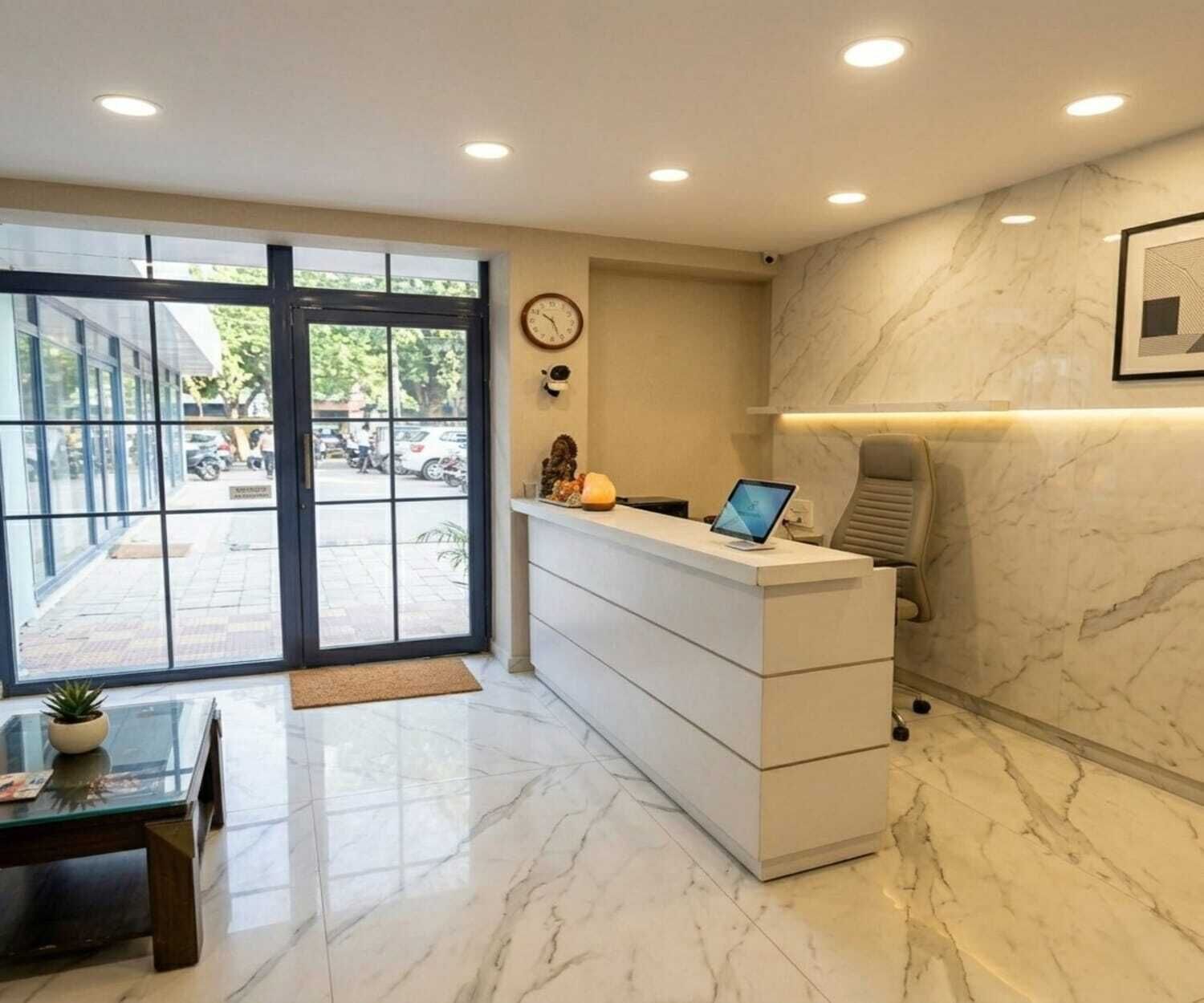 A reception desk with a computer, a clock, and a chair.