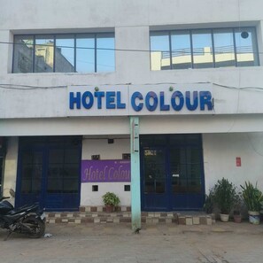 Un edificio con un letrero que dice 'HOTEL COLOUR' y un letrero más pequeño debajo que indica 'Hotel Colour'.