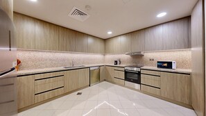 Una cocina moderna con armarios de madera, horno de acero inoxidable y microondas empotrado.