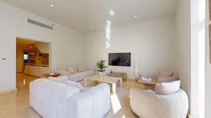 A modern living room with a sofa set, a coffee table, and a TV mounted on the wall. - Aesthetic Four-Level 4 Bedroom l near Marina Walk (Dubai Marina)