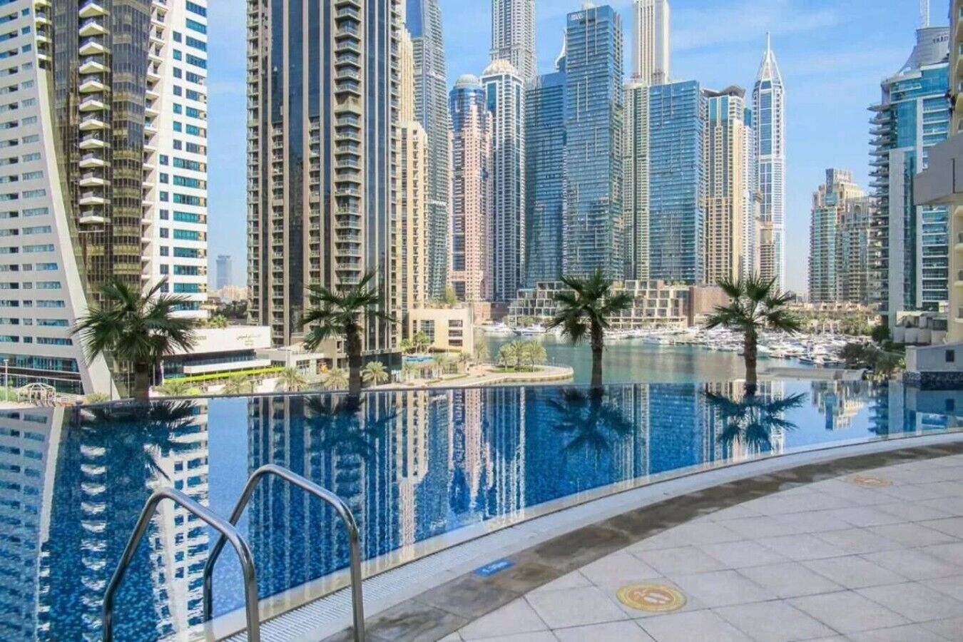 A swimming pool with a view of tall buildings and palm trees.