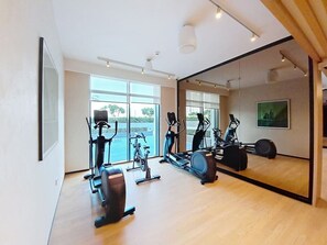 A gym with exercise equipment, large windows, and a mirror. - Contemporary 2 Bed in Creek l Free WiFi & Pool (Creek Harbour)