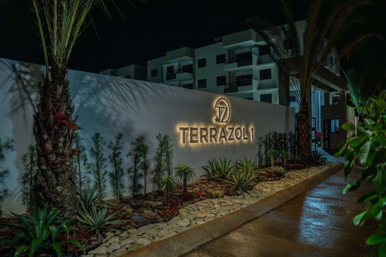 Ein Schild für 'TERRAZOLI' mit einem modernen Gebäude im Hintergrund.