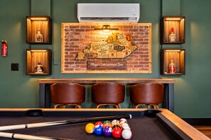 A billiards table with balls and cues, a pool table, and a wall with a map and text.
