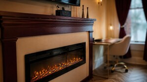 A modern fireplace with a television above it, a 'REMOTE' sign, and a desk with a chair in the background.