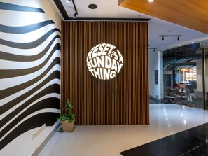 Een modern interieur met een wandbord waarop staat 'RESET IT'S A SUNDAY THING'.