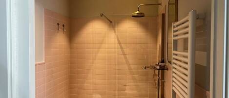 A bathroom with a shower, a sink, and a towel rack.