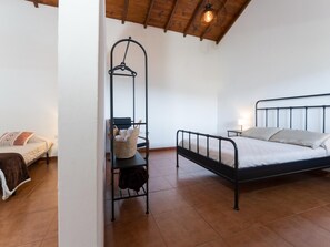 Une chambre à coucher avec un lit, un fauteuil suspendu, une table de chevet et une lampe.