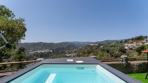 Une piscine sur le toit offrant une vue dégagée sur un paysage vallonné.