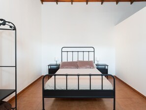 A single bed with a metal frame, two bedside tables with lamps, and a wall-mounted shelf. - Vivelorural casa Priya, pool and views (Teror)