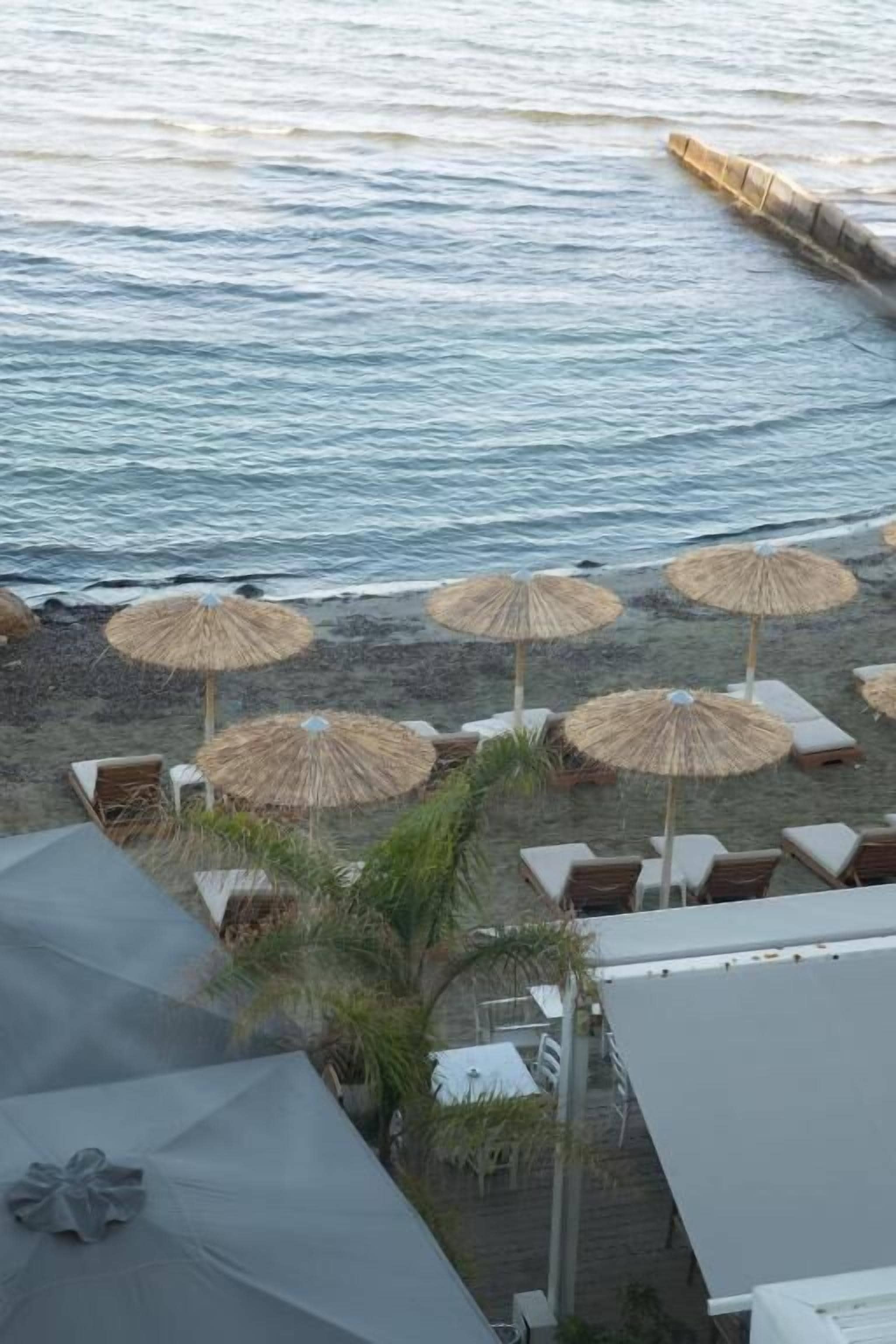 A beachside view with umbrellas and lounge chairs.