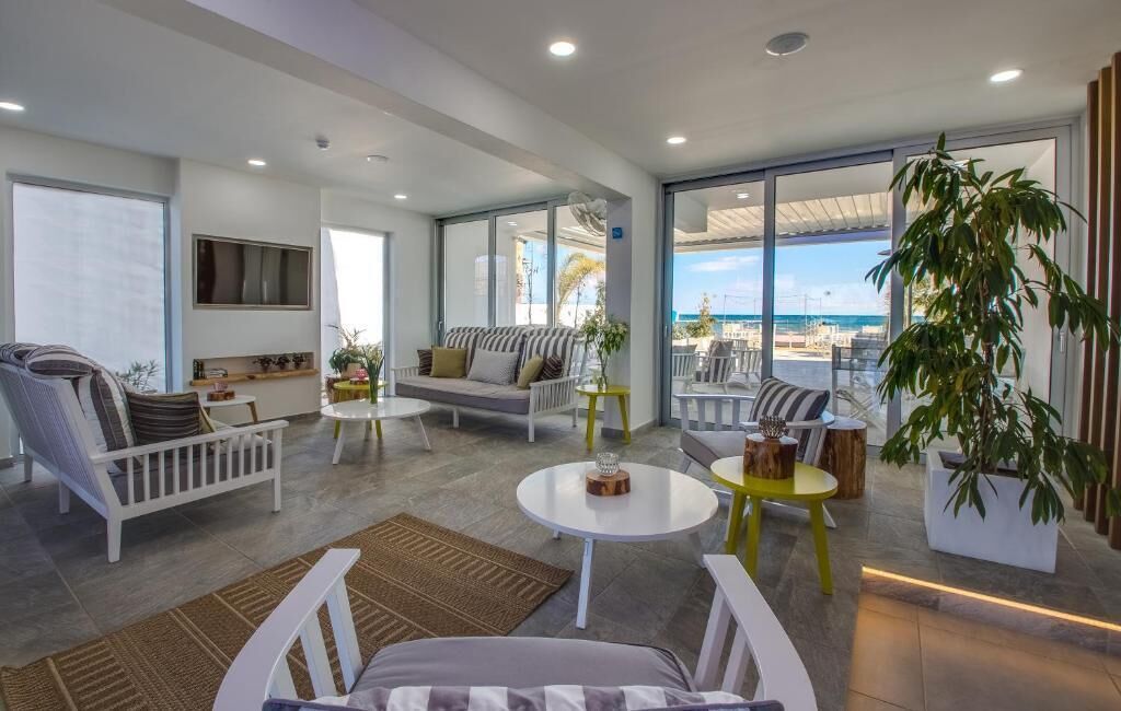 A spacious living area with a sofa, chairs, and a dining table.