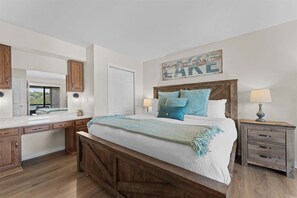 Un dormitorio con una cama de madera, una mesita de noche, un aparador, un espejo y un cartel en la pared.
