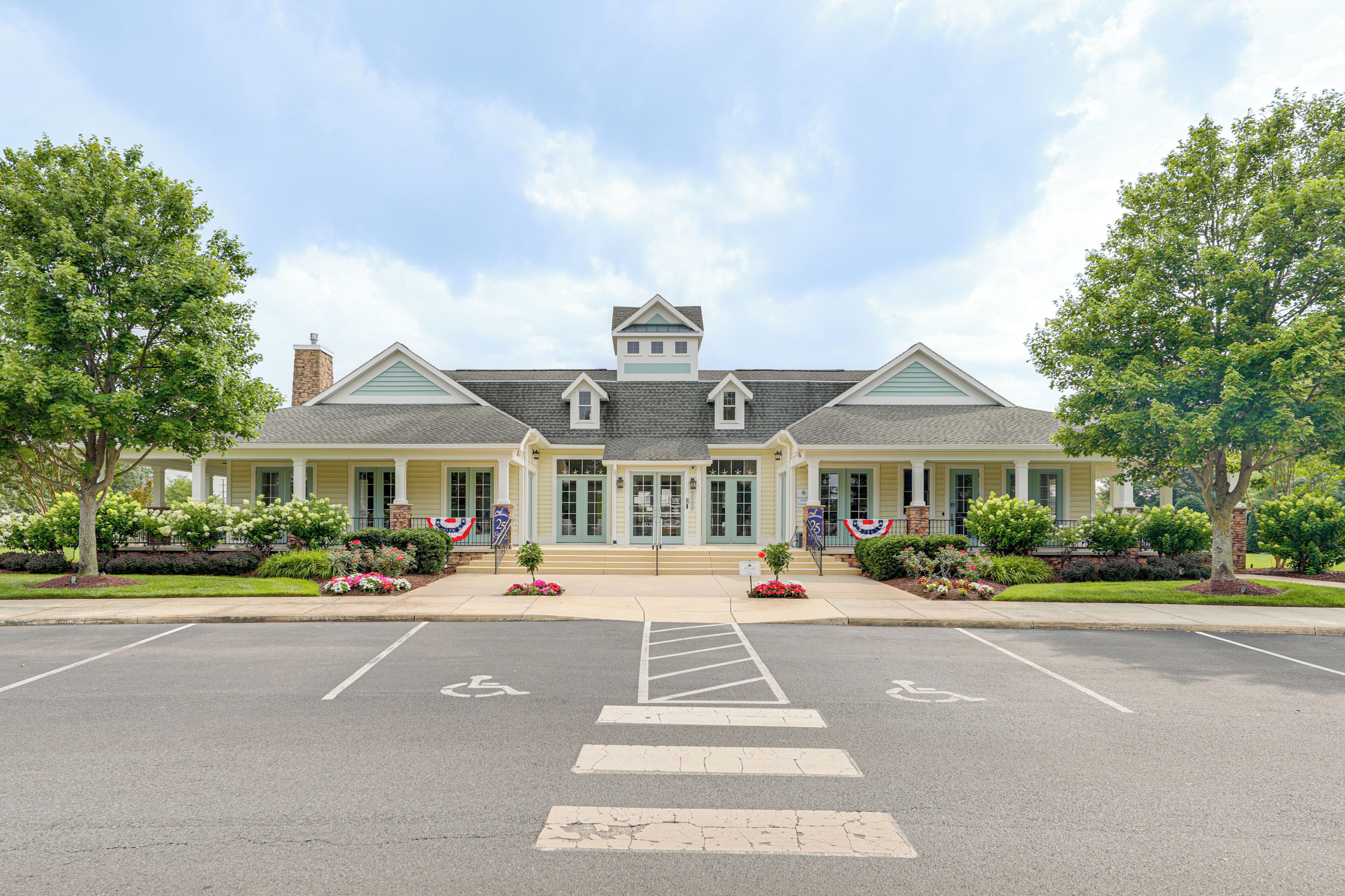 A two-story building with a central entrance, a covered porch, and a parking lot with marked handicapped spaces.