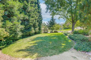 A well-maintained garden with a variety of trees and shrubs, a clear pathway, and a grassy area. - Spacious Home w/ Private Pool, Mins to Folsom Lake (Loomis)