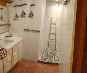 Un baño con ducha, lavamanos e inodoro.
