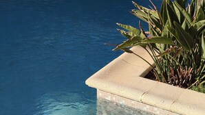 A clear pool with a stone wall and tropical plants. - Stunning villa with ocean views, 100 meters from the beach (Roquebrune-sur-Argens)