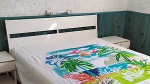 A bed with a colorful floral bedspread, a white headboard, and a nightstand with a lamp. - Stunning villa with ocean views, 100 meters from the beach (Roquebrune-sur-Argens)