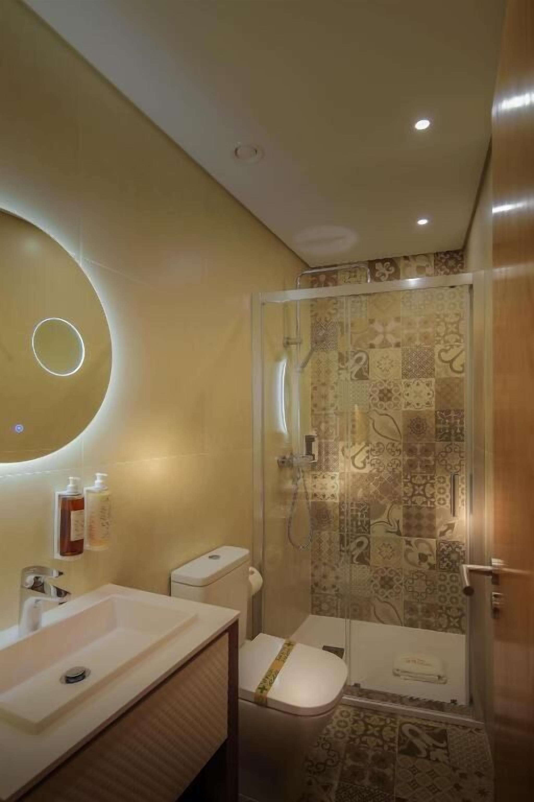Un baño con inodoro, lavamanos y zona de ducha.