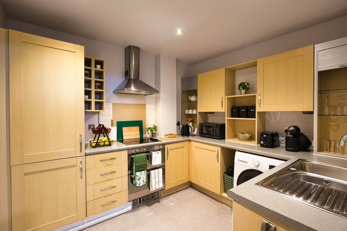 A modern kitchen with wooden cabinets, stainless steel appliances, and a built-in oven.