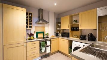A modern kitchen with wooden cabinets, stainless steel appliances, and a built-in oven.
