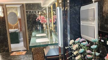 Un baño moderno con cabina de ducha de vidrio, encimeras de mármol y un mueble de tocador con espejo.