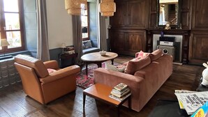 A living room with leather sofas, a coffee table, and a fireplace. - Large Auvergne-style house with a pool, pétanque court, and bread oven (Saint-Martin-Cantalès)