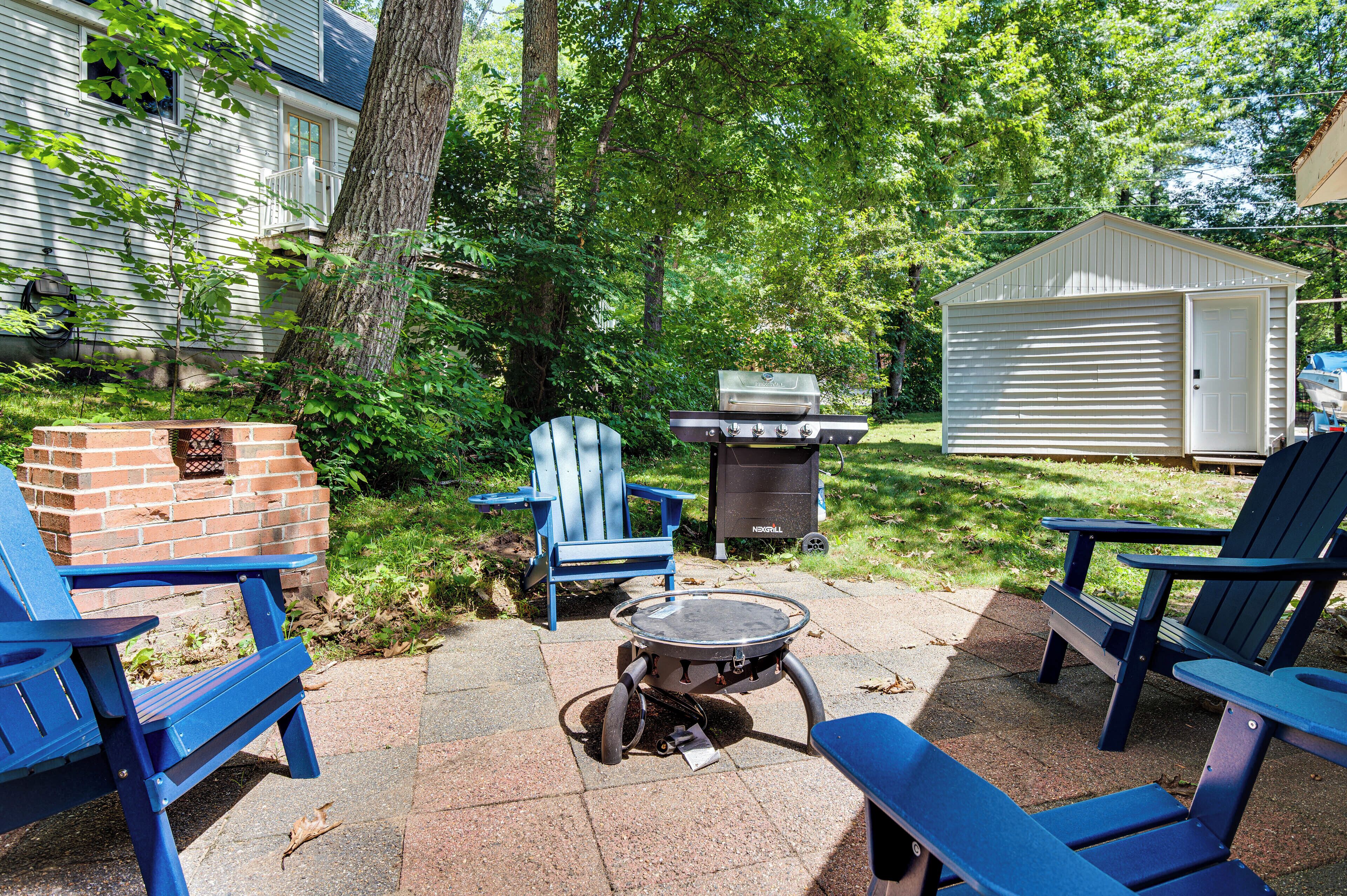 Ein Garten mit Grill, Stühlen und einem Schuppen.