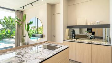 Una cocina moderna con encimeras de mármol, armarios de madera y un espejo grande.