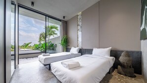 Habitación de hotel moderna con dos camas, un ventanal grande y vistas a zonas verdes.