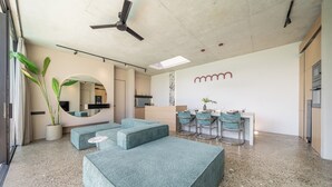 Un interior moderno con una zona de estar, cocina y bar.