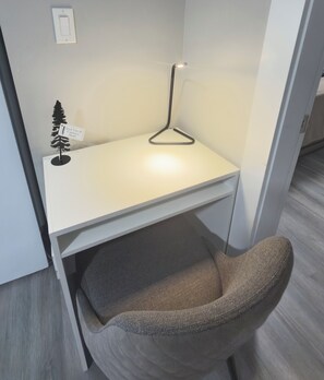 A modern office cubicle with a desk, chair, and a small decorative tree.