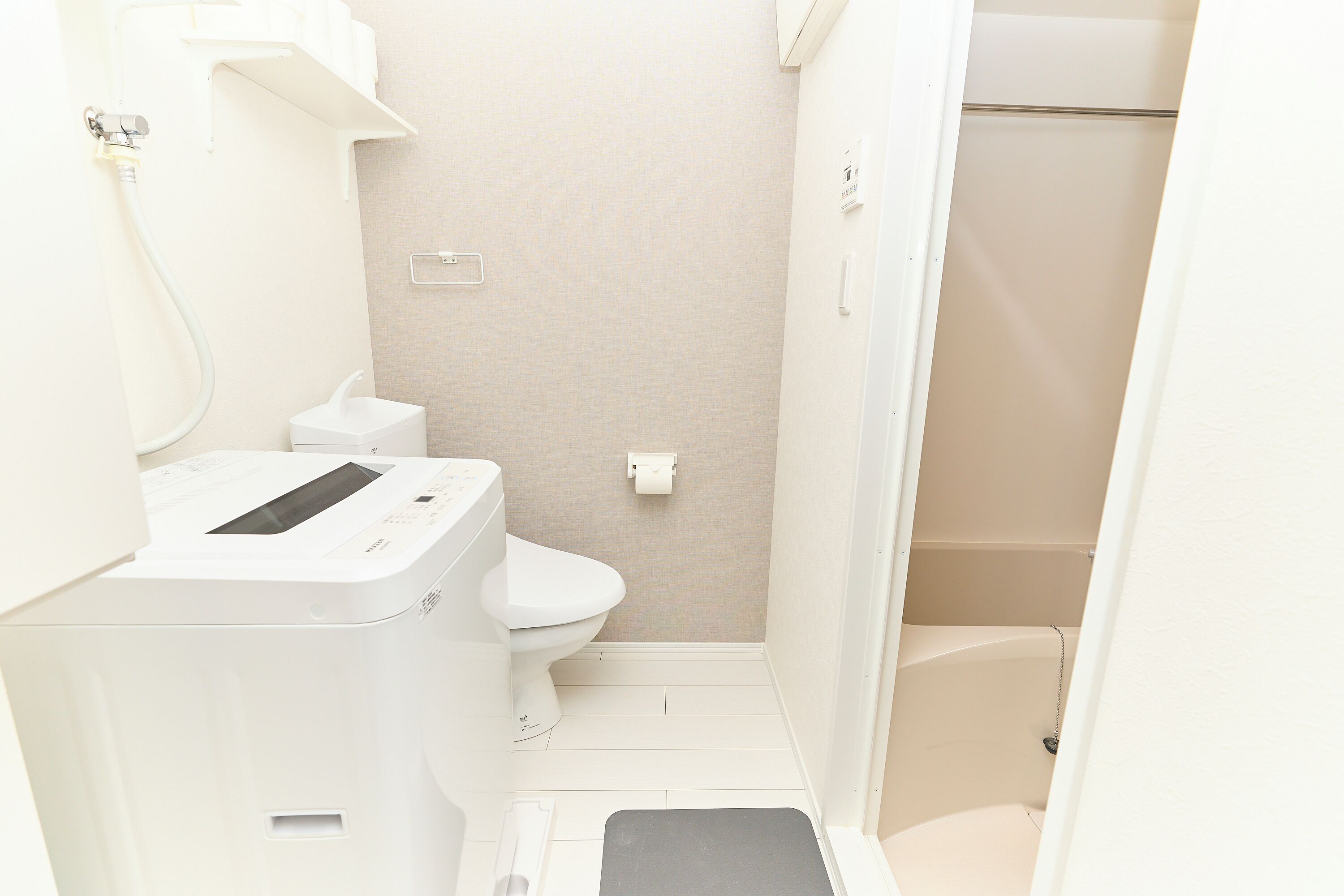 A small, compact bathroom with a toilet, a sink, and a shower area.