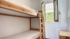 A bunk bed with a wooden ladder, a window with curtains, and a small wooden cabinet. - Cosy Garden Flat, Beach, Pool – Mountain View, Private Pool, Air Conditioning (Akti Idras)