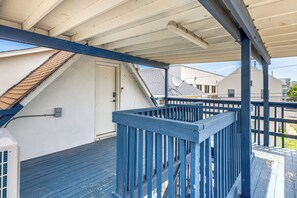 A covered outdoor area with a blue railing, a white door, and a satellite dish on the roof. - Walk to Beach & Boardwalk! Seaside Heights Apt (Seaside Heights)
