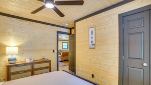Ein Schlafzimmer mit einem Bett, einem Schminktisch, einer Lampe und einem Deckenventilator.