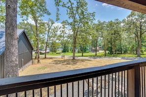 A wooden deck with a view of a grassy area, trees, and a building with a sloped roof. - Family & Pet Friendly! Murray Cabin w/ Lake Access (Murray)